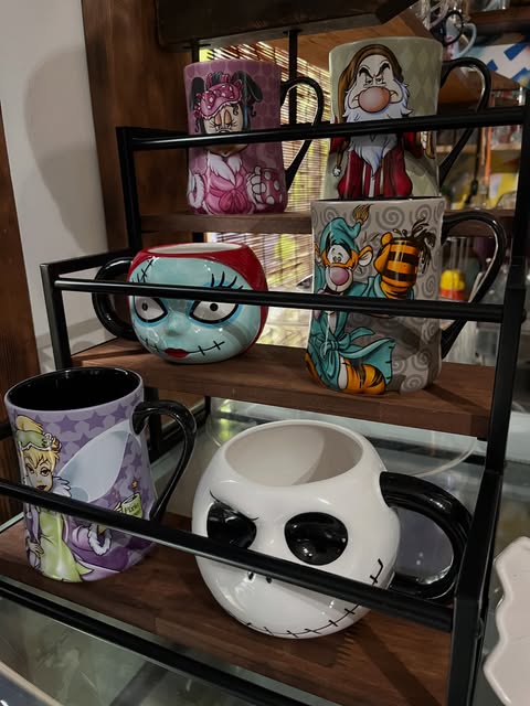 Shelves of whimsical vintage character mugs inside the gallery
